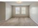 This empty bedroom has neutral walls, carpeted floor, two windows and great natural light at 440 Pinevale Ct, Atlanta, GA 30349