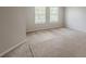 An empty carpeted bedroom with neutral walls and two windows offering natural light at 440 Pinevale Ct, Atlanta, GA 30349