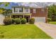 Charming two-story home with a well-manicured lawn, lush bushes, and a brick and siding facade, inviting and well maintained at 440 Pinevale Ct, Atlanta, GA 30349