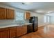 View of a kitchen with wood cabinets, a black refrigerator, and hardwood floors at 440 Pinevale Ct, Atlanta, GA 30349