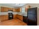 Traditional kitchen with wooden cabinets, appliances, and hardwood floors offering functionality and storage at 440 Pinevale Ct, Atlanta, GA 30349