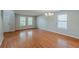 An open living area featuring hardwood floors, a chandelier, and multiple windows at 440 Pinevale Ct, Atlanta, GA 30349