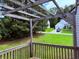 Backyard view from deck showcasing a wooden pergola, green lawn, and a glimpse of the house next door at 133 Magazine St, Dallas, GA 30157