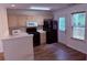 Open concept kitchen with wood cabinets, laminate countertops, and black appliances at 133 Magazine St, Dallas, GA 30157