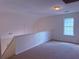 Open loft area featuring neutral carpet, a large window, and a railing at 133 Magazine St, Dallas, GA 30157