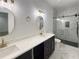 Bathroom featuring double vanity, modern lighting, quartz counters and a spacious glass enclosed shower at 243 Roxbury Dr, Riverdale, GA 30274