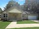 Charming brick home featuring a gabled entry, covered porch, manicured lawn and an attached two car garage at 243 Roxbury Dr, Riverdale, GA 30274