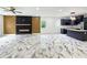 Bright living space features modern fireplace, herringbone accent wall, gorgeous floors, and kitchen with island at 243 Roxbury Dr, Riverdale, GA 30274
