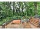 Wooden deck with a hot tub and outdoor seating surrounded by lush trees and greenery at 3229 Richwood Dr, Duluth, GA 30096