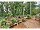 Outdoor wooden deck featuring potted plants, flowers, treed backdrop, and an array of decor at 3229 Richwood Dr, Duluth, GA 30096