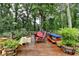 Wooden deck with colorful seating, vibrant flowers, and a wooded backdrop for outdoor enjoyment at 3229 Richwood Dr, Duluth, GA 30096