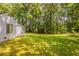 Home's backyard featuring a lush lawn and wooded backdrop at 6200 Beaver Creek Trl, Atlanta, GA 30349