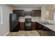 Functional kitchen with dark cabinets, modern appliances, and tile flooring at 6200 Beaver Creek Trl, Atlanta, GA 30349