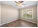 Cozy bedroom with hardwood floors, a ceiling fan, and a bright window overlooking the neighborhood at 213 Riverstone Commons Cir, Canton, GA 30114
