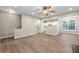 Open living space with wood floors, neutral walls, ceiling fan, and staircase at 213 Riverstone Commons Cir, Canton, GA 30114