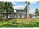 A view of the backyard featuring a green lawn, mature trees and gray exterior of home at 2849 Snapfinger Rd, Decatur, GA 30034