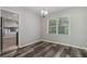 Dining room with a modern light fixture, wood-look floors, and view of a stainless steel refrigerator at 2849 Snapfinger Rd, Decatur, GA 30034