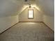 Finished attic space with neutral carpet, trim, and natural light from single window at 340 Sherwood Se Cir, Conyers, GA 30094