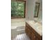 A traditional bathroom with double sinks, wood cabinets and a bathtub at 340 Sherwood Se Cir, Conyers, GA 30094