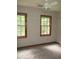 Bright bedroom featuring hardwood floors, two windows, and a ceiling fan at 340 Sherwood Se Cir, Conyers, GA 30094