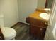 Small powder room with wood look floors, a cabinet sink, and a standard white toilet at 340 Sherwood Se Cir, Conyers, GA 30094