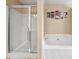 Modern bathroom featuring a glass-enclosed shower and a soaking tub with stylish wall art at 44 Providence Oak Ct, Lawrenceville, GA 30046