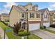 Side view of a tan townhome showcasing the corner lot and well-maintained landscaping at 44 Providence Oak Ct, Lawrenceville, GA 30046