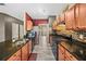 Galley kitchen featuring dark countertops, stainless steel appliances, and wood cabinets at 44 Providence Oak Ct, Lawrenceville, GA 30046