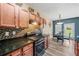 Kitchen featuring wood cabinets, dark countertops, stainless steel appliances, and an adjacent dining area at 44 Providence Oak Ct, Lawrenceville, GA 30046