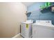 Efficient laundry room featuring a washer, dryer, and overhead shelving for storage at 44 Providence Oak Ct, Lawrenceville, GA 30046