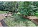 Beautiful backyard with stone patio and seating area, nestled amongst mature trees at 5245 Cottage Farm Rd, Johns Creek, GA 30022