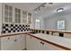 Bright bar area features a sink, built-in cabinets, counterspace, and a black and white checkered backsplash at 5245 Cottage Farm Rd, Johns Creek, GA 30022