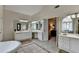 Bright bathroom features dual vanities, tile floors, soaking tub and an entrance to an additional room at 5245 Cottage Farm Rd, Johns Creek, GA 30022