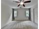 Bright bedroom featuring carpet, ceiling fan, and two windows at 5245 Cottage Farm Rd, Johns Creek, GA 30022