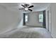 Spacious bedroom with carpet, ceiling fan, and natural light from two windows at 5245 Cottage Farm Rd, Johns Creek, GA 30022