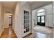 Inviting foyer with hardwood floors, glass paneled doors, and an arched window at 5245 Cottage Farm Rd, Johns Creek, GA 30022