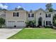 Elegant exterior with a manicured lawn, classic shutters, and a welcoming two-car garage at 5245 Cottage Farm Rd, Johns Creek, GA 30022