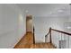 A wooden staircase leads to a bright hallway with hardwood floors and high ceilings at 5245 Cottage Farm Rd, Johns Creek, GA 30022
