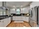 Bright kitchen features white cabinets, dark countertops, stainless appliances, and hardwood floors at 5245 Cottage Farm Rd, Johns Creek, GA 30022
