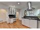 Open-concept kitchen with white cabinets, stainless steel hood, and hardwood floors at 5245 Cottage Farm Rd, Johns Creek, GA 30022