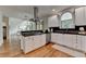 Eat-in kitchen features white cabinets, dark countertops, stainless appliances, and hardwood floors at 5245 Cottage Farm Rd, Johns Creek, GA 30022