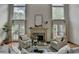 Elegant living room showcasing a fireplace, tall windows, and comfortable seating, creating a cozy and inviting space at 5245 Cottage Farm Rd, Johns Creek, GA 30022