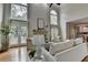 Bright living room featuring large windows, hardwood floors, a fireplace, and neutral decor at 5245 Cottage Farm Rd, Johns Creek, GA 30022