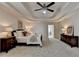 The stylish bedroom features plush carpet, dark furniture, and a beautiful tray ceiling at 5245 Cottage Farm Rd, Johns Creek, GA 30022