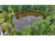 Aerial view of community pond surrounded by trees, with a fountain in the center at 5245 Cottage Farm Rd, Johns Creek, GA 30022