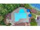 Aerial view of a community pool area with blue umbrellas and lounge chairs surrounded by trees at 5245 Cottage Farm Rd, Johns Creek, GA 30022