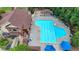 Aerial view of a large community pool with lounge chairs and umbrellas near a brick clubhouse at 5245 Cottage Farm Rd, Johns Creek, GA 30022