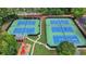 Aerial view of well-maintained tennis courts and a colorful playground surrounded by lush greenery at 5245 Cottage Farm Rd, Johns Creek, GA 30022