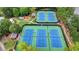 Aerial view of well-maintained tennis courts and playground surrounded by lush greenery at 5245 Cottage Farm Rd, Johns Creek, GA 30022