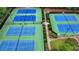 Overhead shot of the tennis courts with green and blue coloring and green hedge rows at 5245 Cottage Farm Rd, Johns Creek, GA 30022